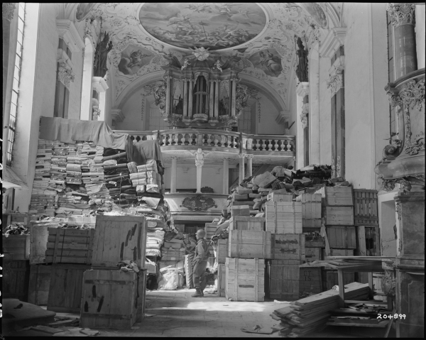 Een Amerikaanse soldaat tussen de door nazi's geroofde kunst in een kerk in Ellingen, Duitsland (24 april 1945) © NARA RG-111-SC-204899