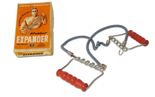 Rubber Expander. Een fitnesstrekveer om thuis het lichaam te trainen.  Collectie Huis van Alijn, midden 20e eeuw.