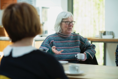 Oudere dame vertelt aan jongere collega. Foto: Age Cymru via Unsplash