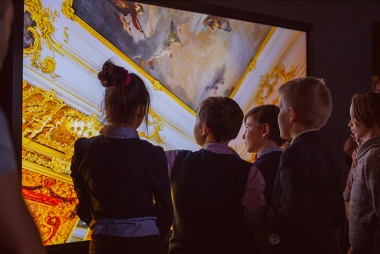 Kinderen staan voor een groot scherm waarop een schilderij getoond wordt. Foto: Leka Sergeeva - shutterstock.com