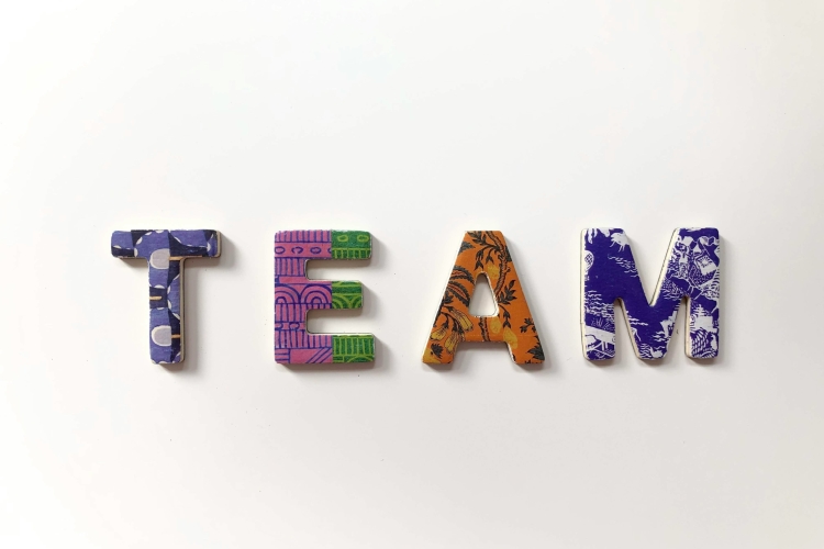 Het woord team in kleur. Foto: Merakist via Unsplash