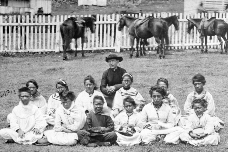 Pater Damiaan met het Kalawao meisjeskoor van Kalaupapa, Molokai, circa 1878. Henry L. Chase via Wikimedia Commons, publiek domein.