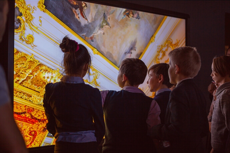 Kinderen staan voor een groot scherm waarop een schilderij getoond wordt. Foto: Leka Sergeeva - shutterstock.com
